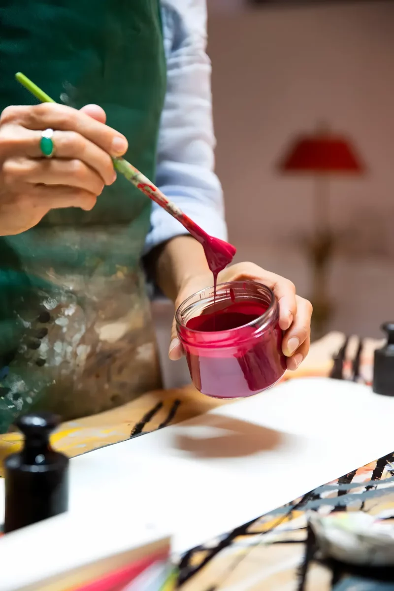 Hand Haellt Farbpinsel Und Glas Mit Roter Farbe